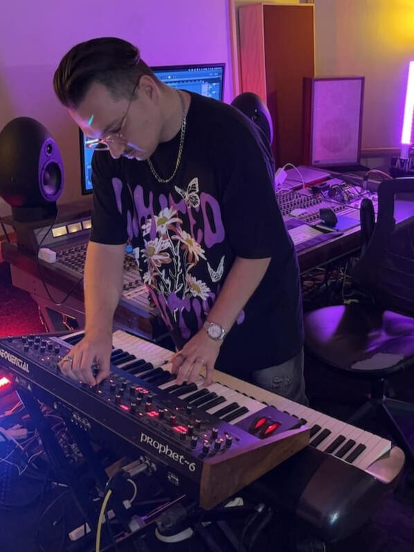 Luka playing a synthesizer in the studio.